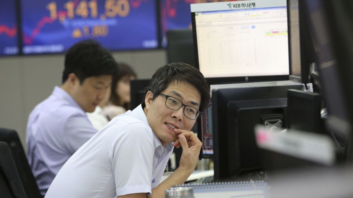 A currency trader watches monitors at the foreign exchange dealing room of the KEB Hana Bank headquarters in Seoul, South Korea.
