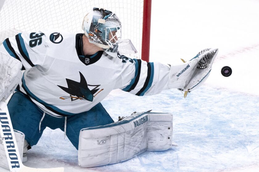 San Jose Sharks goaltender Kaapo Kahkonen deflects the puck off his glove during the first period of the tema's NHL hockey game against the Montreal Canadiens on Tuesday, Nov. 29, 2022, in Montreal. (Paul Chiasson/The Canadian Press via AP)