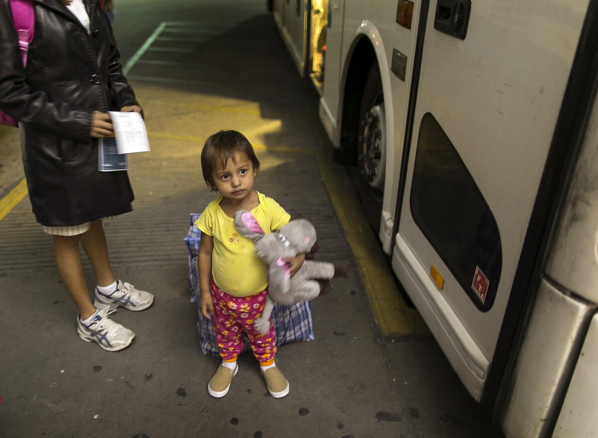 Adriana Ortez, 2, holds her stuffed animal as she and her mother, Dayana Ortez, of El Salvador, wait to board a bus leaving the city bus station in McAllen, Texas. The mother and daughter were heading to Los Angles to be reunited with family.