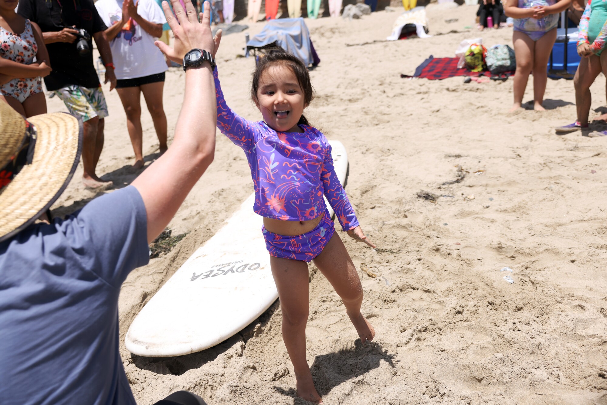 Umi Fabiola Kobayashi tape dans les mains d'un instructeur lors d'un cours de surf à First Point.