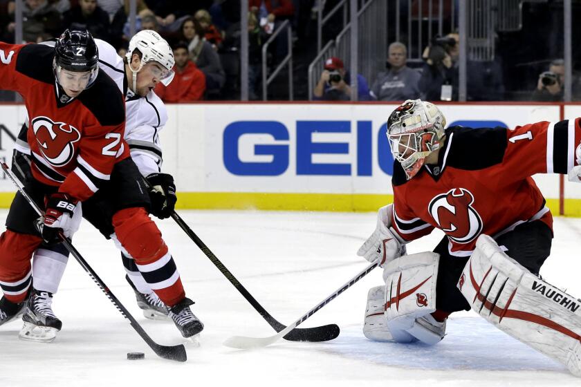 Devils defenseman John Moore (2) tries to clear the puck away from Kings left wing Tanner Pearson (70), who is looking for a shot against Devils goalie Keith Kinkaid (1) in the first period Sunday.
