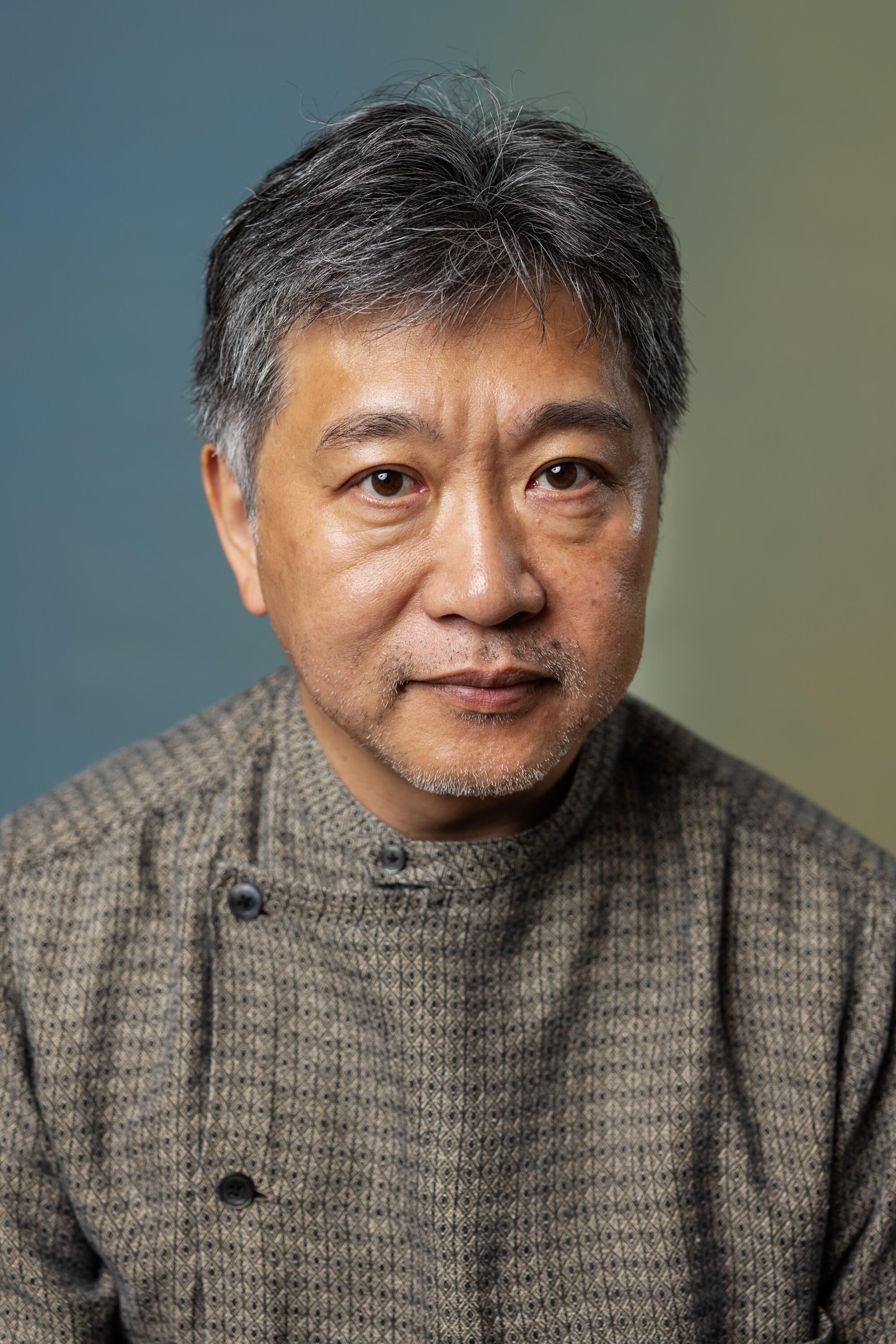 Kore-eda wears a patterned shirt buttoned on the side
