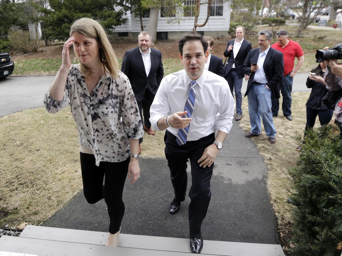 Republican presidential candidate Marco Rubio enters the home of Jenna Pedone, left, for a campaign house party in Manchester, N.H.