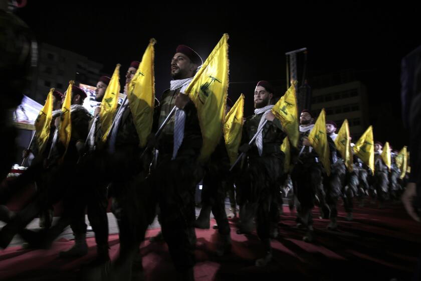 FILE - In this May 31, 2019 file photo, Hezbollah fighters march at a rally to mark Jerusalem day, in the southern Beirut suburb of Dahiyeh, Lebanon. As Lebanon sinks deeper into poverty and collapse, many Lebanese are more openly criticizing the Iran-backed Hezbollah, blaming it for its role in the devastating, multiple crises plaguing the country. This includes a dramatic currency crash and severe shortages in medicines and fuel that has paralyzed the country. (AP Photo/Hassan Ammar, File)