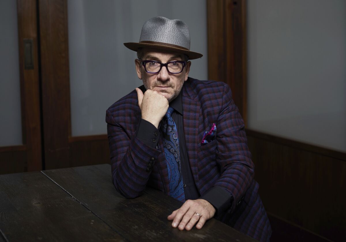 FILE - Elvis Costello poses for a portrait at The Redbury New York hotel in New York on Sept. 17, 2018. Costello's new album, the coronavirus-era disc "The Boy Named If" was made in solitary style — four musicians, five if you count a backup singer on one song — all worked from their own homes. He says that conjures the image of a laid-back sound, but the new disc is an up-tempo, guitar-based selection of crankin' rock songs. (Photo by Matt Licari/Invision/AP, File)