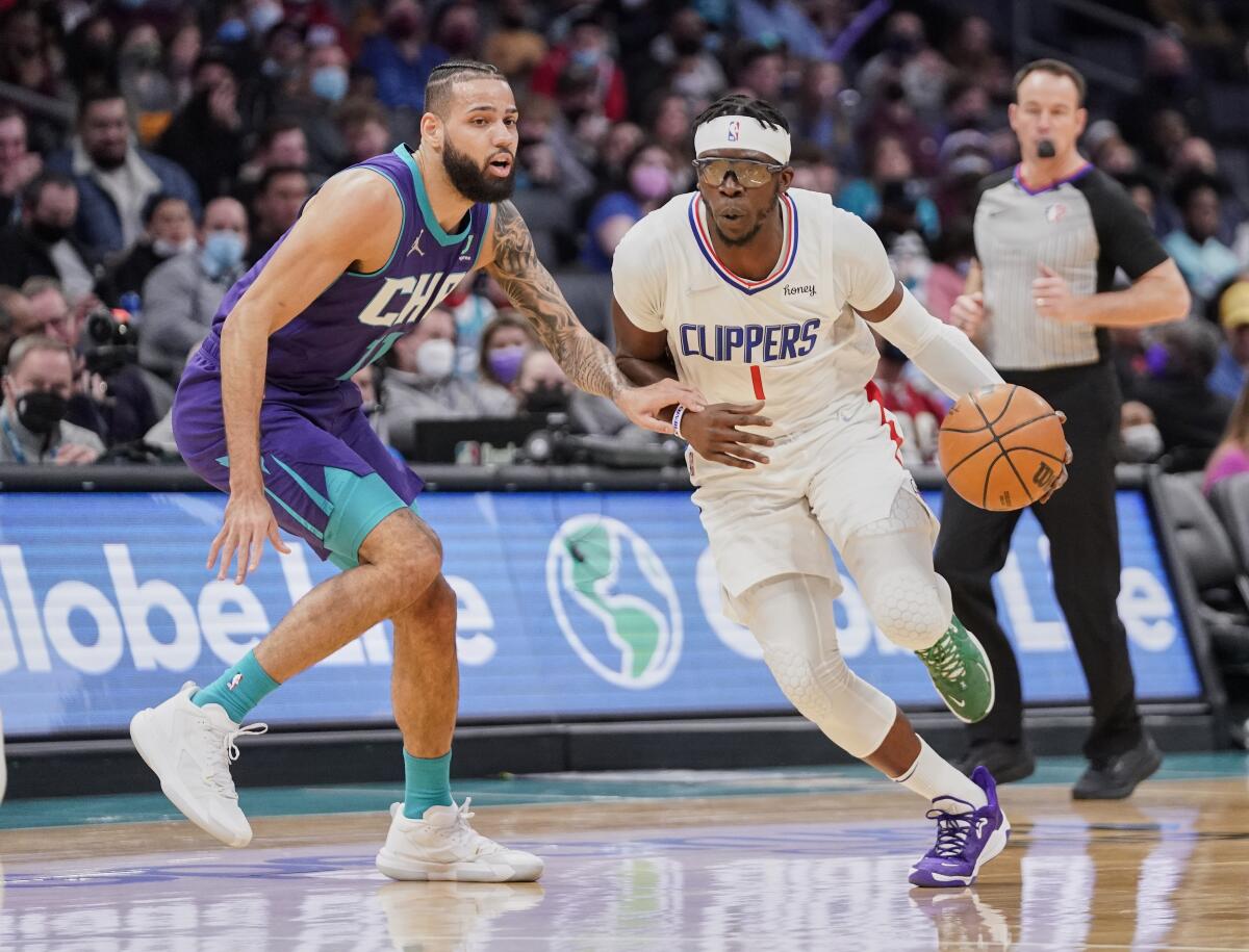 Clippers guard Reggie Jackson drives around Charlotte Hornets forward Cody Martin.