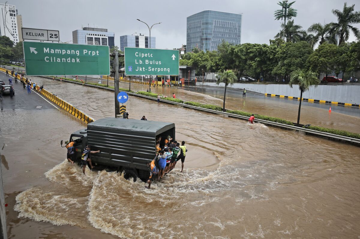 FILE - A military truck drives through the water on a flooded toll road following heavy rains in Jakarta, Indonesia, Saturday, Feb. 20, 2021. A United Nations Intergovernmental Panel on Climate Change report released on Monday, Feb. 28, 2022, says a staggering 143 million people will be uprooted over the next 30 years by rising seas, searing temperatures and other climate calamities. (AP Photo/Dita Alangkara, File)