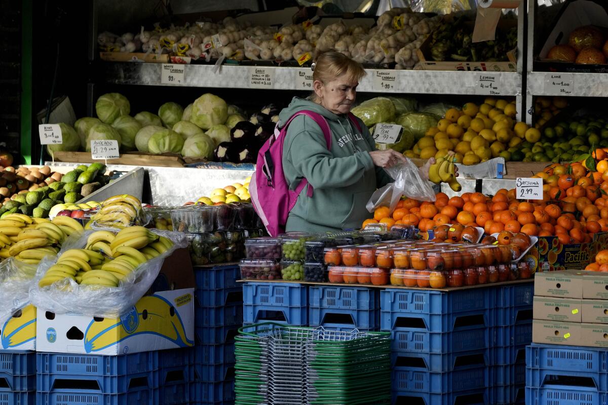FILE - A woman selects fruits at a supermarket in London, Wednesday, Nov. 17, 2021. The Office for National Statistics said Wednesday, Aug. 17, 2022, that consumer prices inflation hit double digits, a jump from 9.4% in June and higher than analysts’ central forecast of 9.8%. The increase was largely due to rising prices for food and staples including toilet paper and toothbrushes, it said. (AP Photo/Frank Augstein, File)