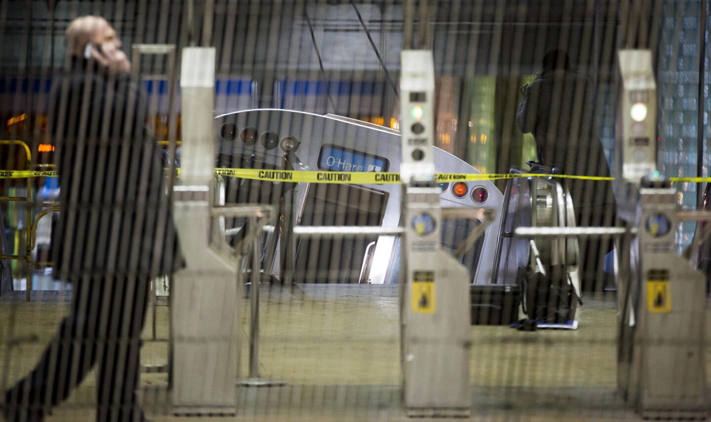 A derailed Chicago Transit Authority train car rests on an escalator at the O'Hare airport station early Monday.