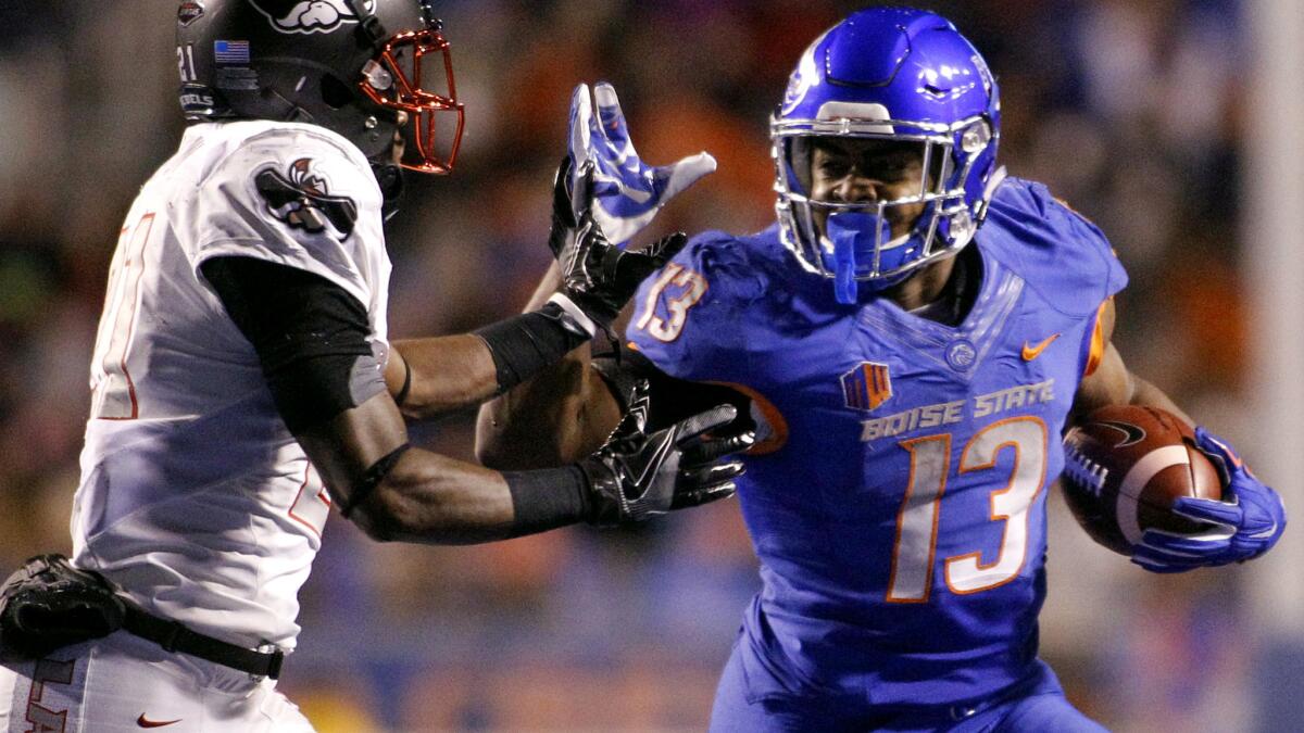 Boise State running back Jeremy McNichols tries to fend off UNLV defensive back Darius Mouton (21) during the second half Friday night.