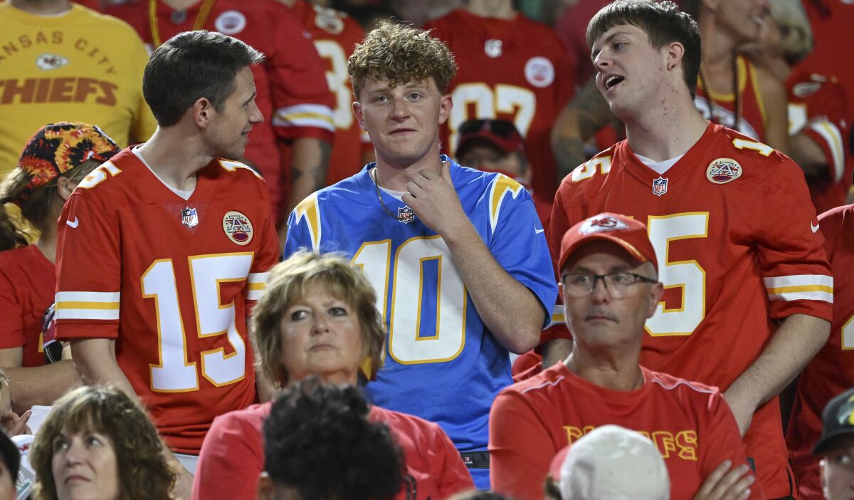 A Chargers fan stands alone among a sea of Kansas City Chiefs fans.
