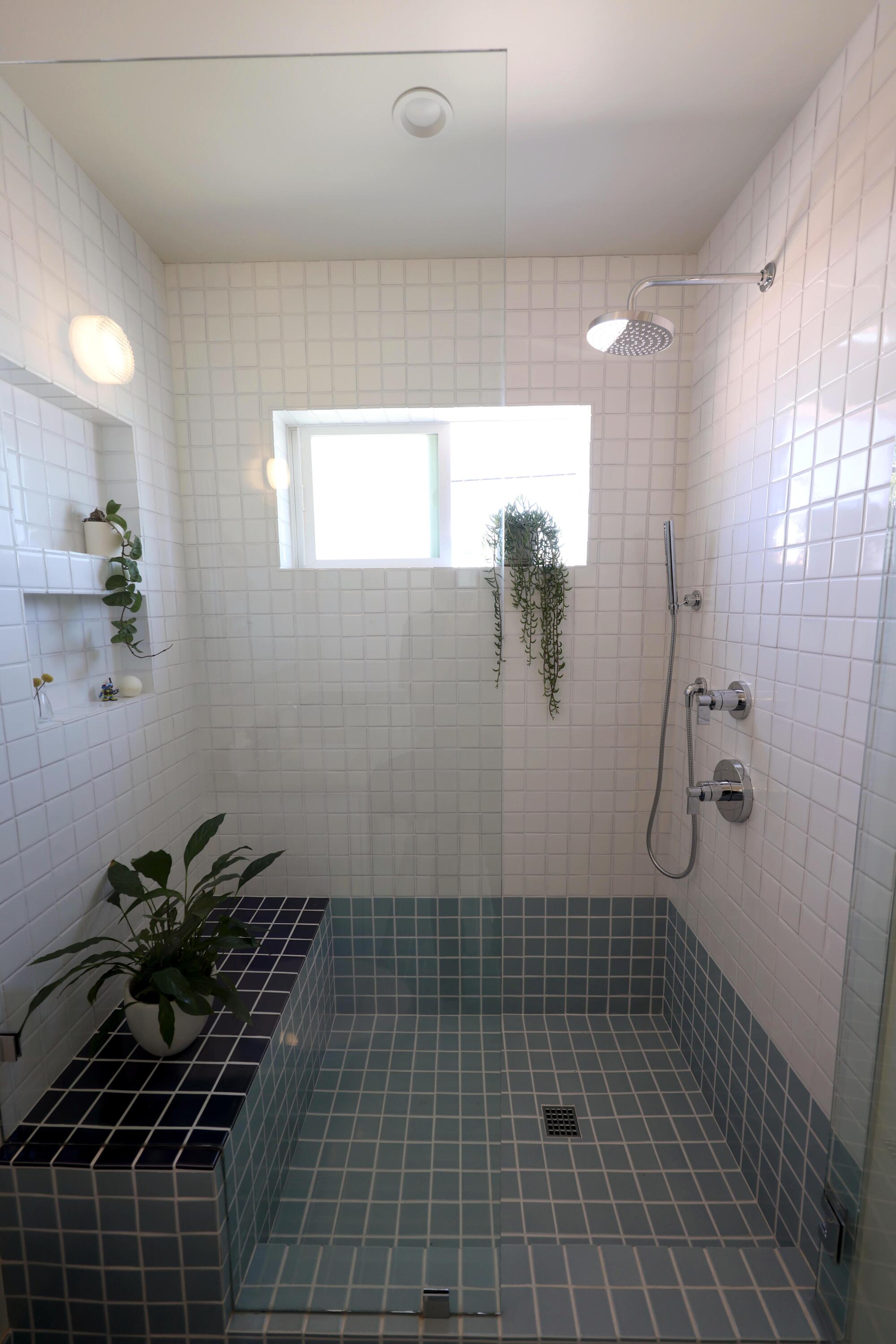 Una cabina de ducha con azulejos azules y blancos. 