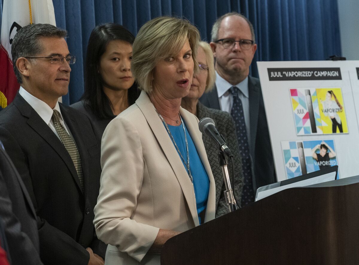 Los Angeles County Supervisor Janice Hahn stands before a microphone.