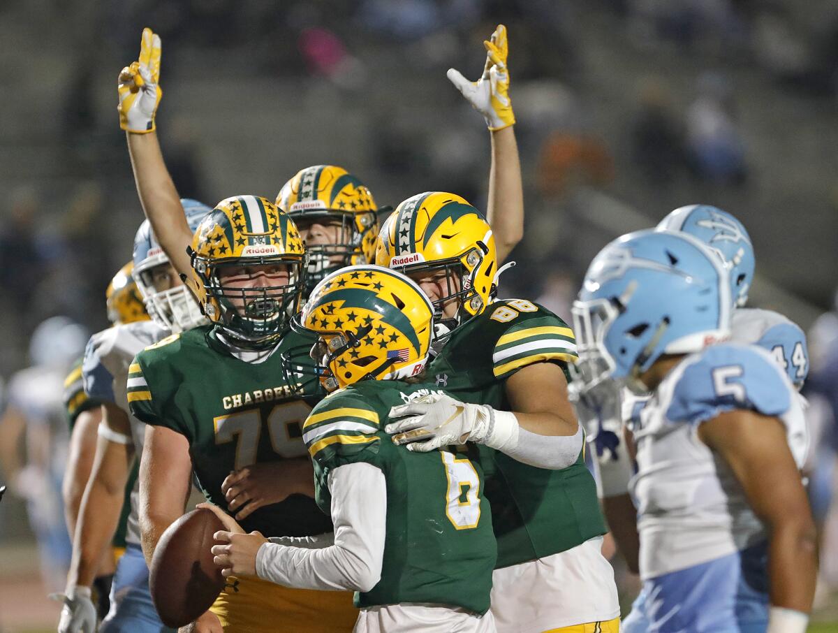 Edison quarterback Braeden Boyles is surrounded by teammates after scoring a rushing touchdown.