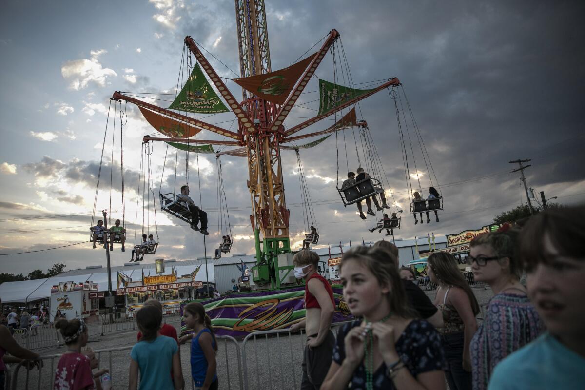 People wait to ride a revolving swing at the Perry State Fair in New Lexington, Ohio.