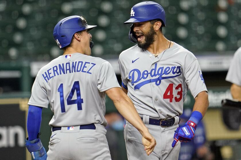 Los Angeles Dodgers' Edwin Rios (43) celebrates with Enrique Hernandez (14) after both scored on Rios' two-run home run against the Houston Astros during the 13th inning of a baseball game Wednesday, July 29, 2020, in Houston. (AP Photo/David J. Phillip)