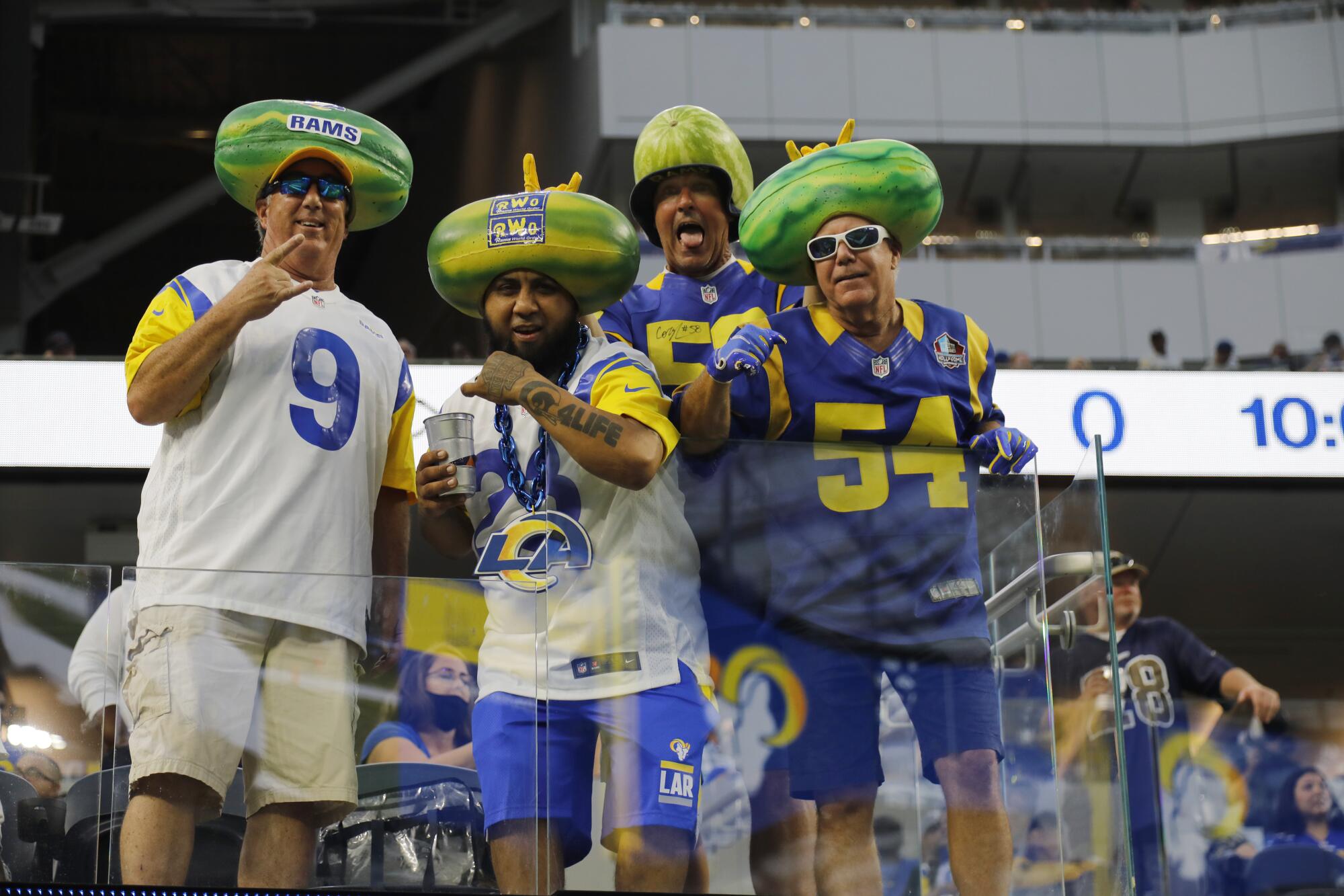 Rams fans with watermelon heads cheer during the first preseason game against the Chargers.