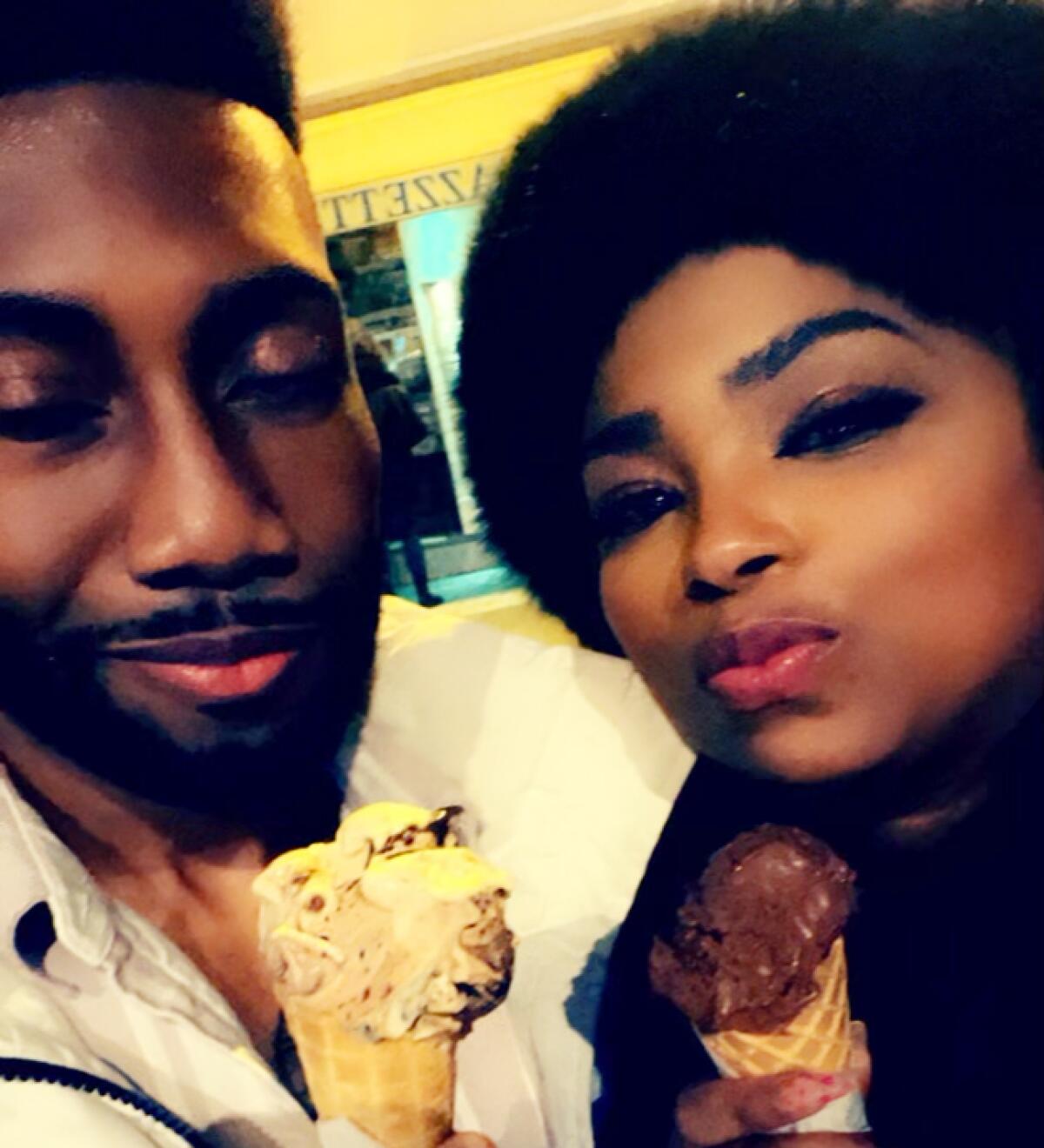 A man and a woman each hold an ice cream cone.
