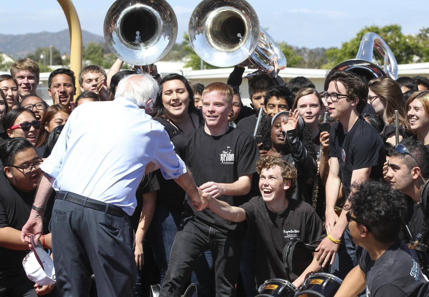 After speaking at the Rancho Buena Vista High School football stadium, Democratic presidential candidate Bernie Sanders shakes hands with members of Rancho Buena Vista's marching band after he posed for a picture with them.