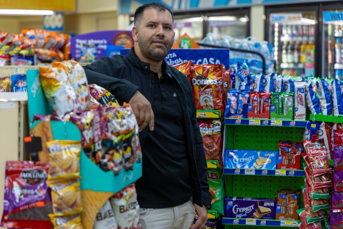 Man standing in the aisles of a gas station convenience store. 