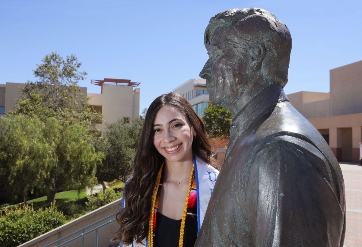 Cal State San Marcos student Krystal Alvarez-Hernandez with the statue of Cesar Chavez on campus
