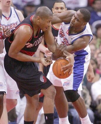 Clippers forward Elton Brand tangles with Portland's Jamaal Magloire as they battle for a loose ball during the first quarter Monday at the Staples Center.