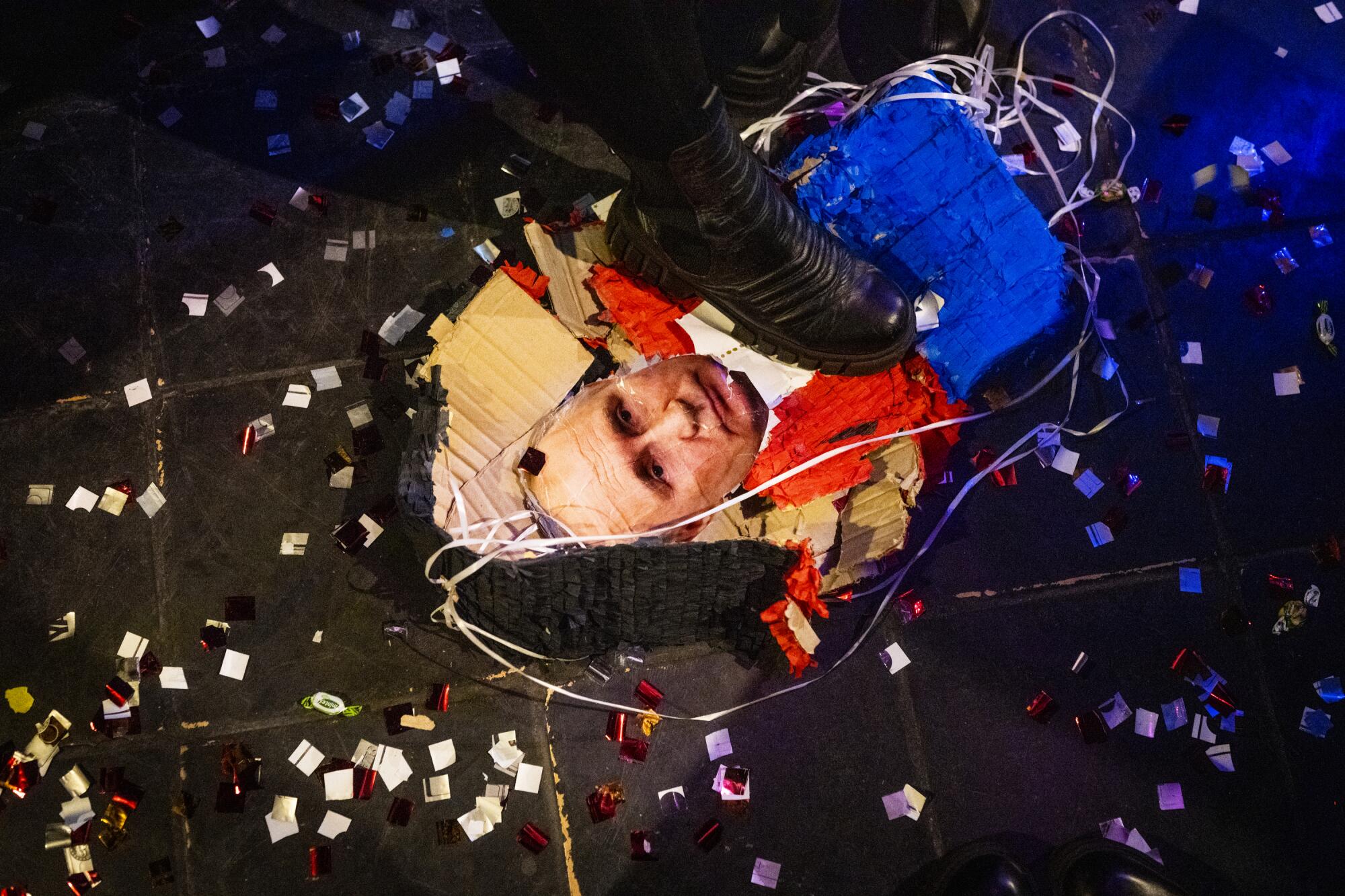 A smashed pi?ata featuring the face of Vladimir Putin on the floor of a bar 