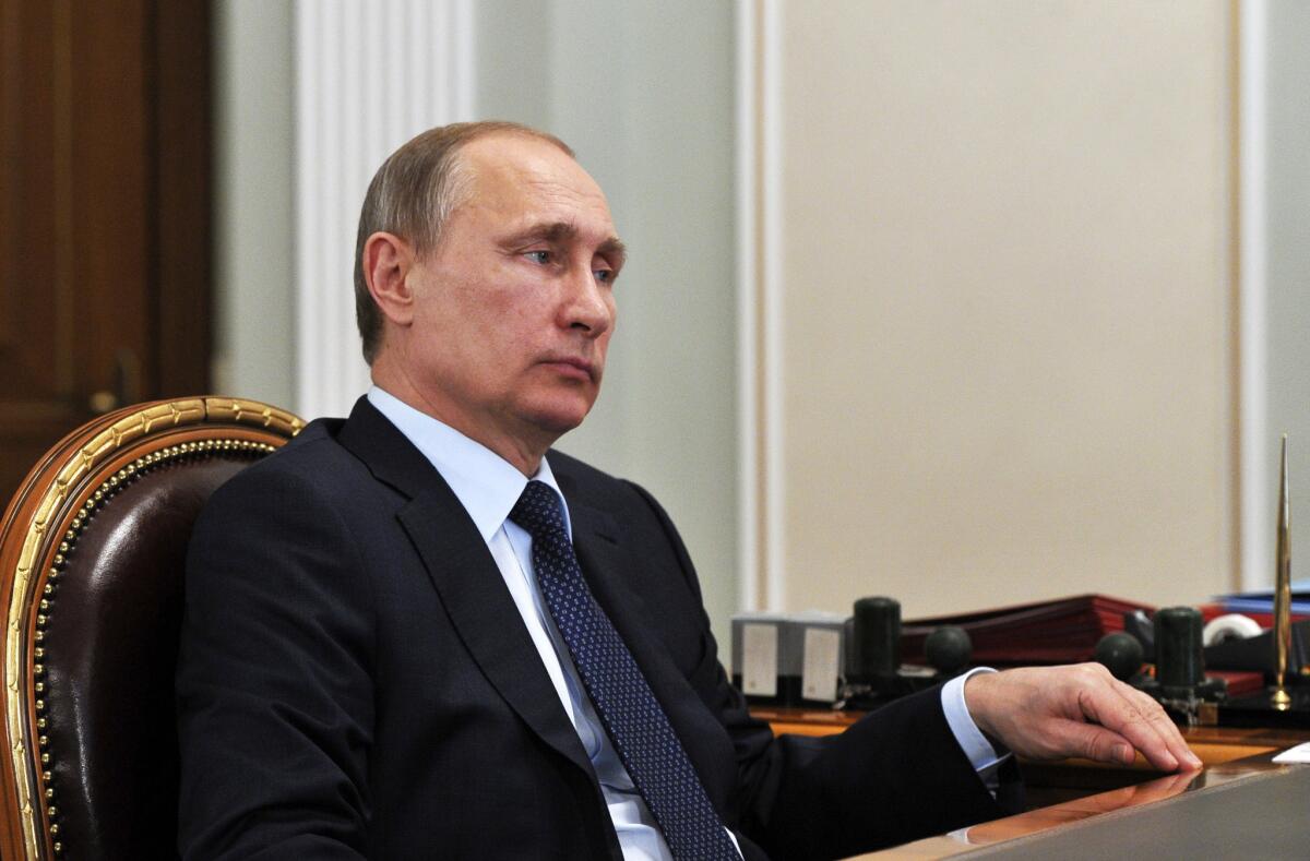 Russian President Vladimir Putin listens during a meeting in the Novo-Ogaryovo residence, outside Moscow. The Kremlin says Russia has lifted its ban on the delivery of an air defense missile system to Iran.
