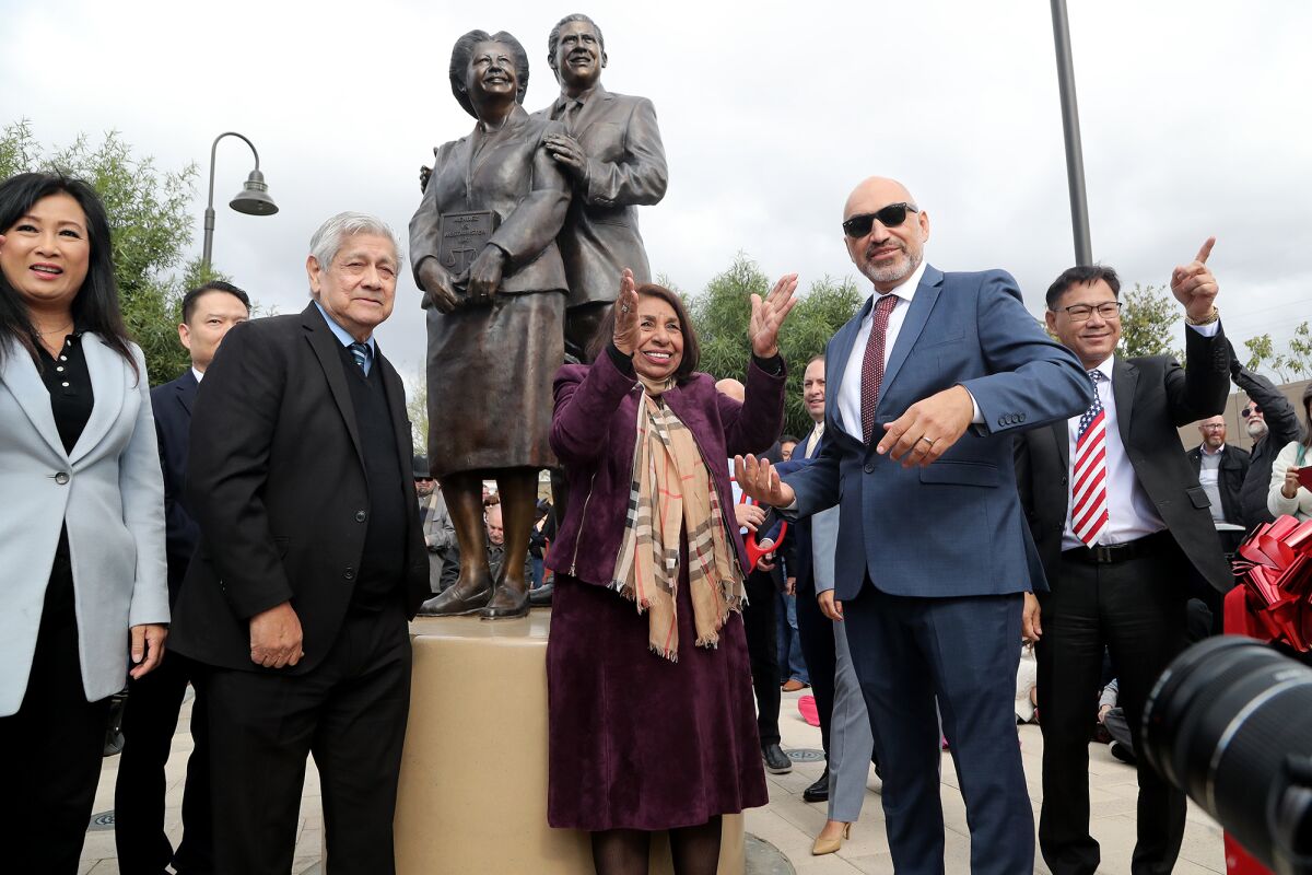 Activist Sylvia Mendez, center, and artist Ignacio Gomez, second from left, attend a statue unveiling of Mendez's parents.