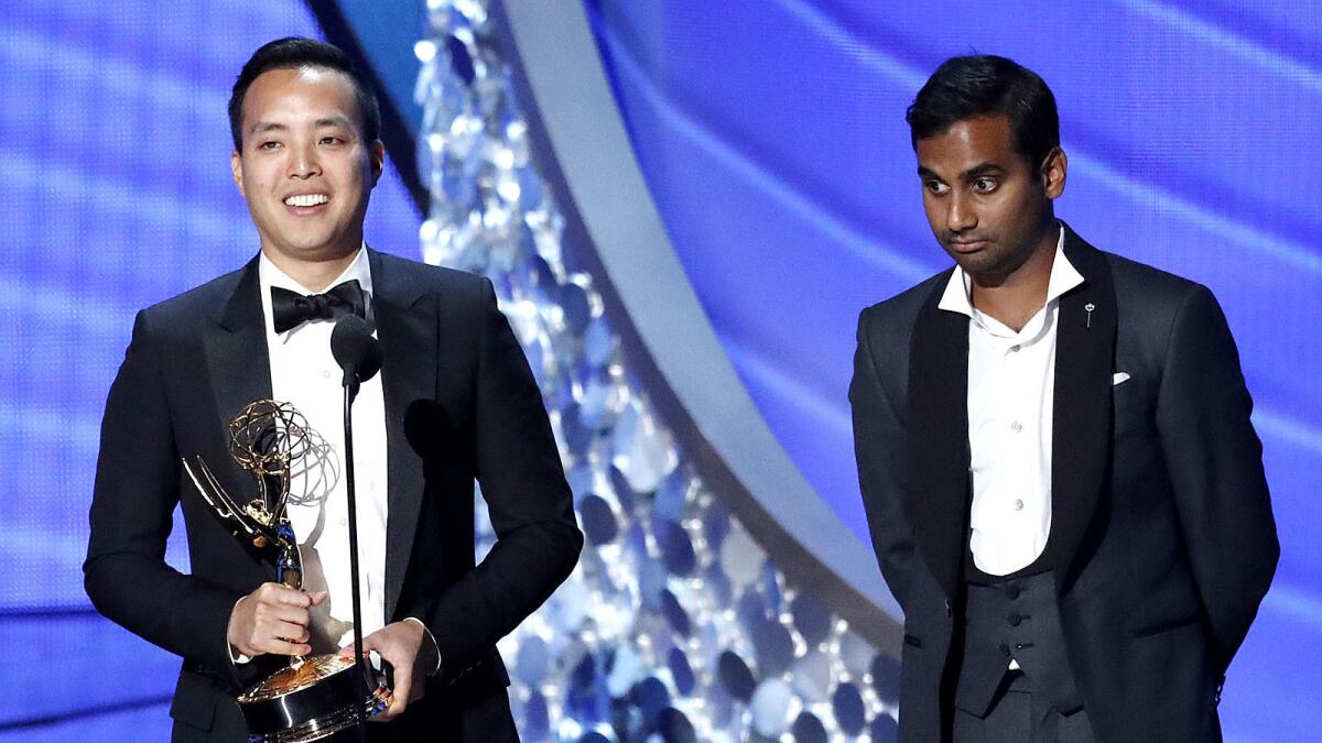 Alan Yang, left, accepts the Emmy for comedy writing with Aziz Ansari.