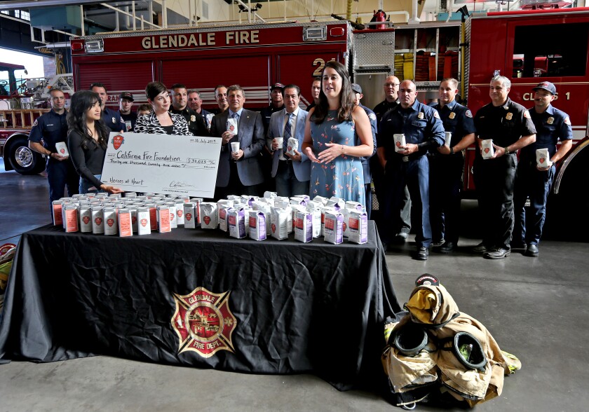 With Ashley Keehne and Kristina Guillen from the Coffee Bean & Tea Leaf at left, California Fire Foundation Director Elena Ruiz speaks about the help that will be provided to residents through the $31,000 donation from the coffee company at Glendale Fire Station 21 on Tuesday.