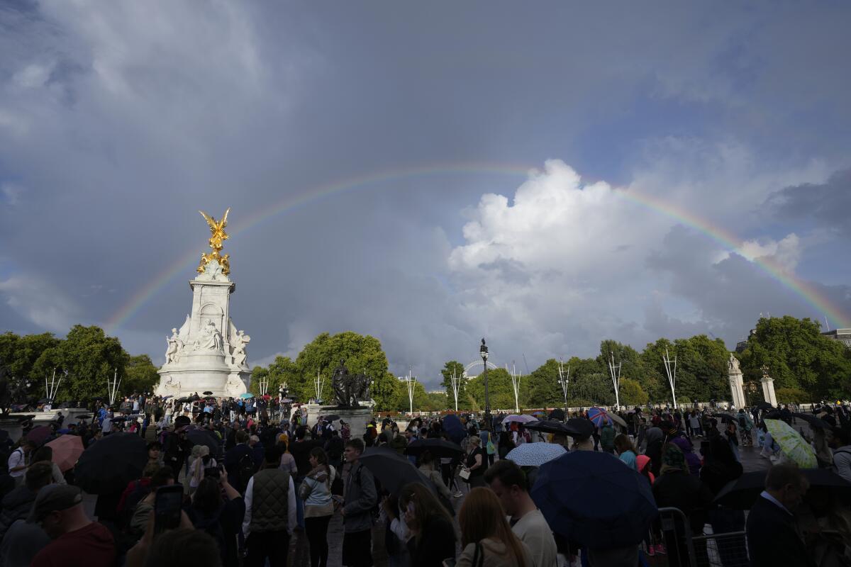 A large crowd gathers outside Buckingham Palace in London.