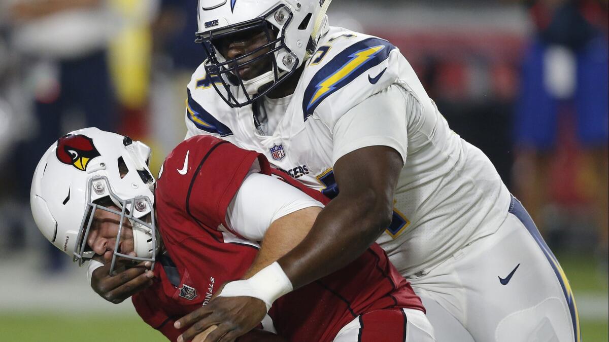 Chargers defensive tackle Corey Liuget (94) grabs the face mask of Arizona Cardinals quarterback Josh Rosen (3) for a 15-yard penalty during the first half of a preseason game on Aug. 11 in Glendale, Ariz.