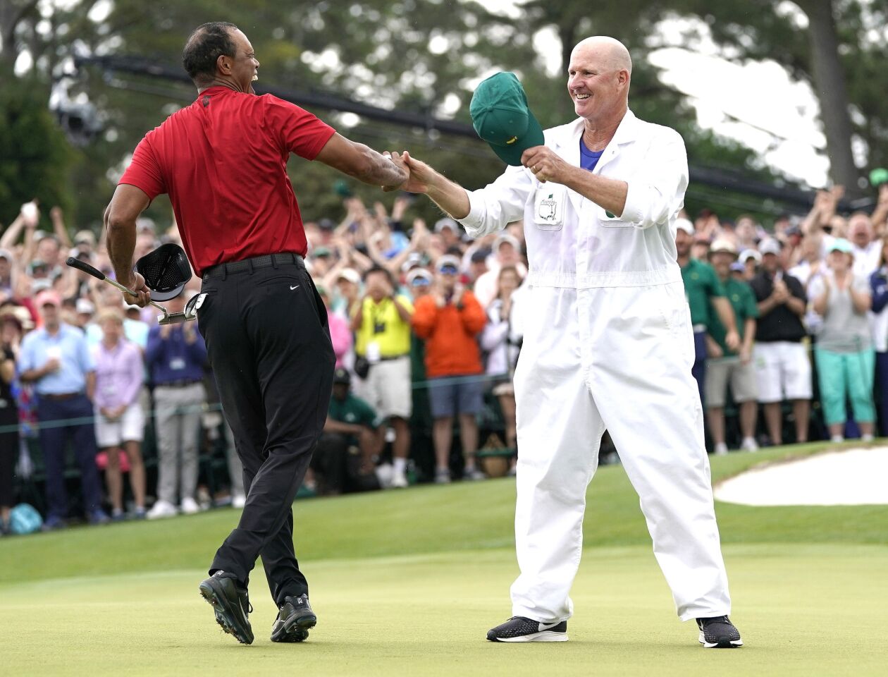 Tiger Woods reacts with his caddie Joe LaCava as he wins the Masters golf tournament Sunday in Augusta, Ga.