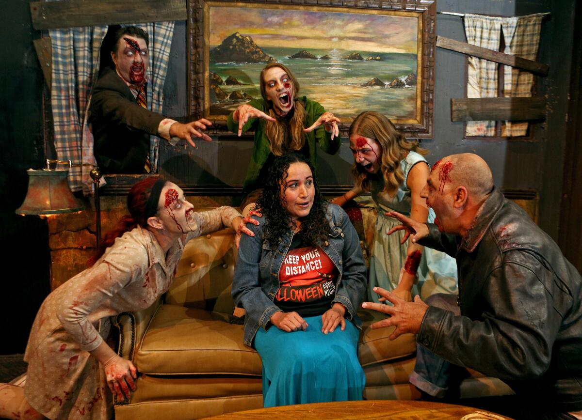 Zombie actors ignore the warning of Peralta's shirt as they surround the "Halloween Every Night" founder