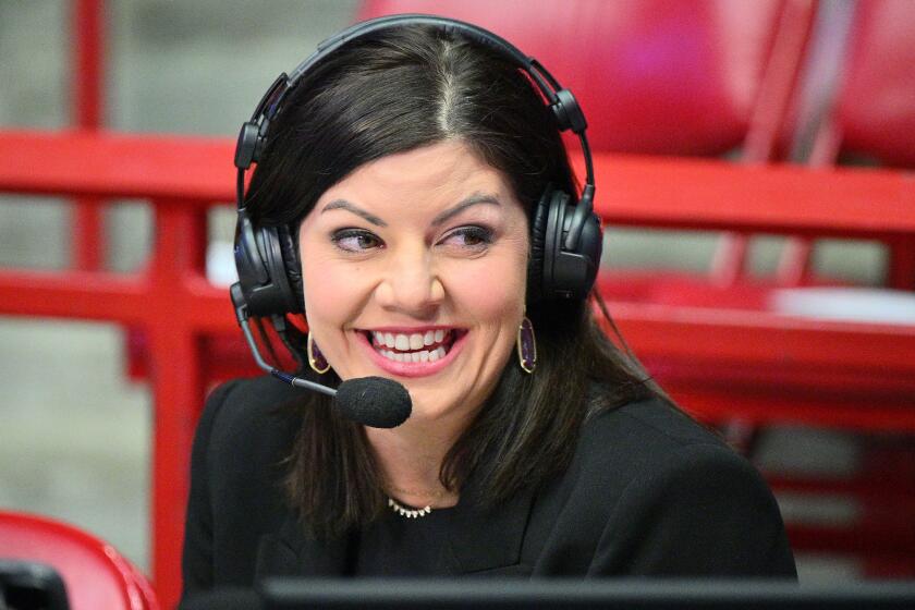 Play-by-play announcer Jenny Cavnar wears a headset before broadcasting a college basketball game.