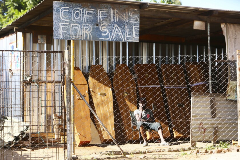 A worker at a coffin making company waits for clients inside the company premises in Harare, Tuesday, Jan. 5, 2021, as Zimbabwe began a 30-day lockdown in a bid to rein in the spike in COVID-19 infections threatening to overwhelm health services. In response to to rising infections the country has reintroduced a night curfew, banned public gatherings, and indefinitely suspended the opening of schools. (AP Photo/Tsvangirayi Mukwazhi)