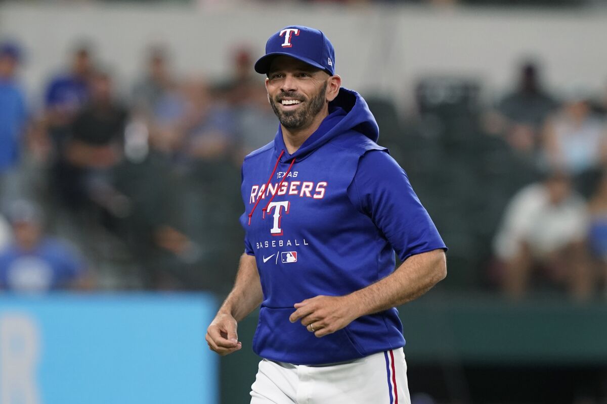 Texas Rangers manager Chris Woodward smiles during a mound visit against the Kansas City Royals.