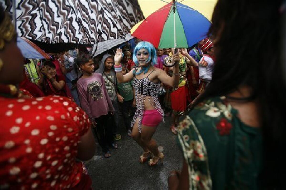 Gays, lesbians, transvestites and their supporters dance as they participate in a gay rally in Pokhara 200 kilometers (125 miles) from Katmandu, Nepal, Friday, Aug. 3, 2012. Hundreds of gay, lesbian and transgender people marched in a Nepal town to demand recognition as a third gender in citizen certificates, to allow same-sex marriage and support criminalizing discrimination based on sexual preference. (AP Photo/Niranjan Shrestha)