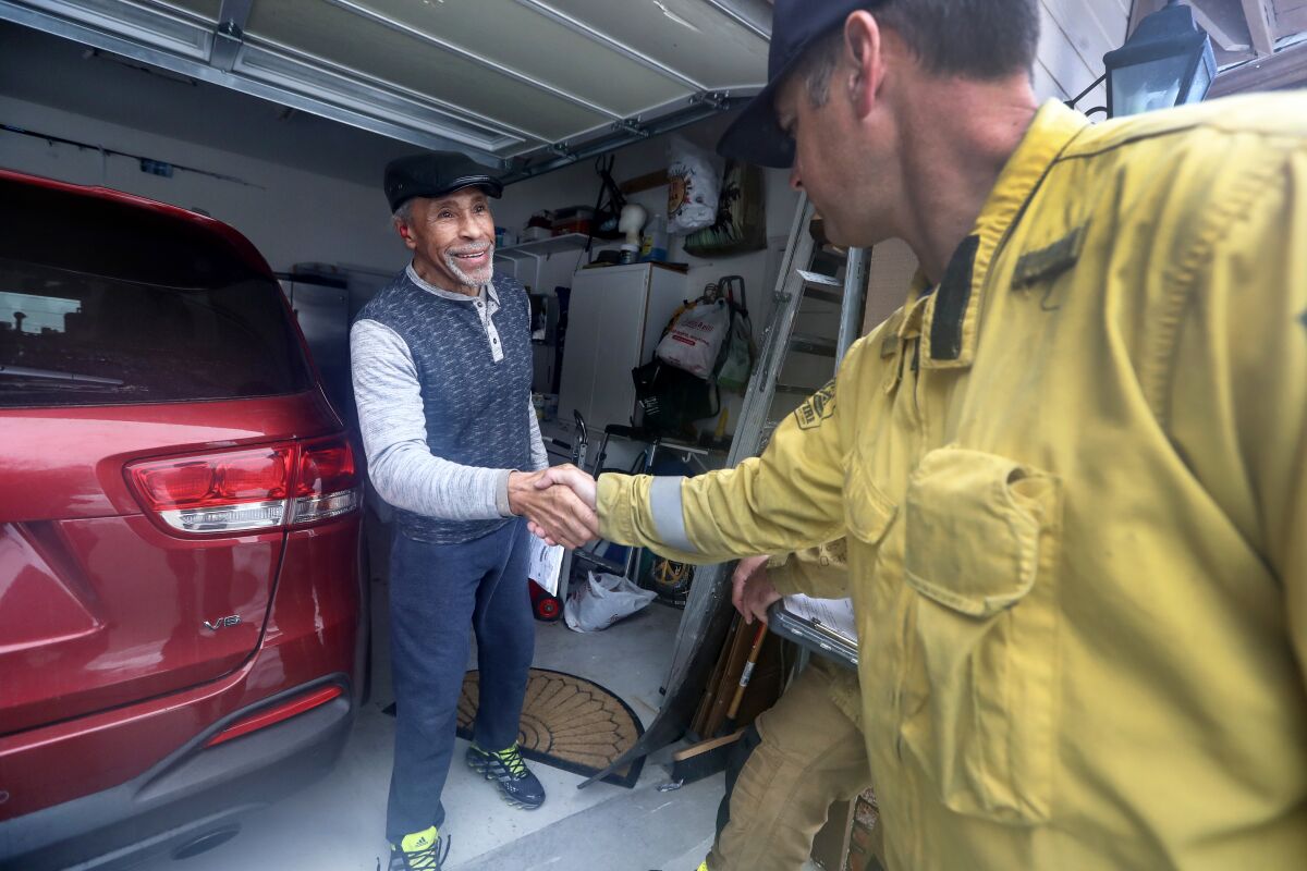 Fire line medic Mike Age, right, greets San Bernardino mountain area resident Leroy Tolliver, 