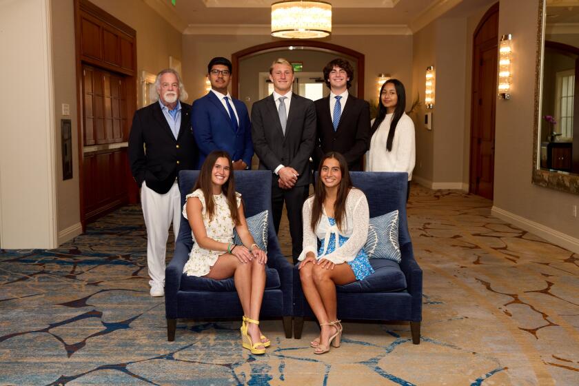 Balboa Bay Club Chairman of the Board of Governors John Wortmann, left, stands with scholarship winners.