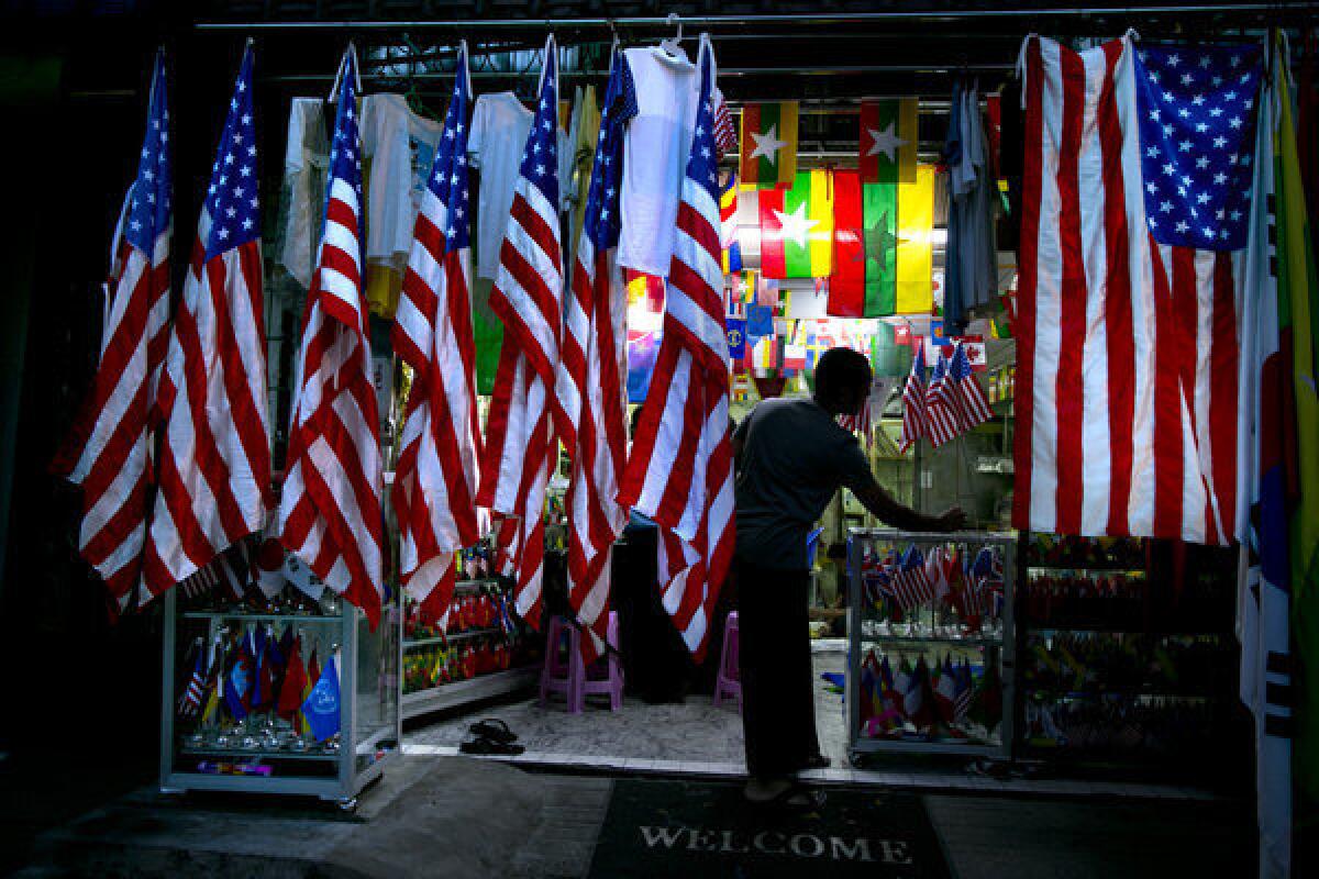 A Burmese worker is seen in a flag shop surrounded by American flags as the city gets excited for President Obama's visit in Yangon, Myanmar.