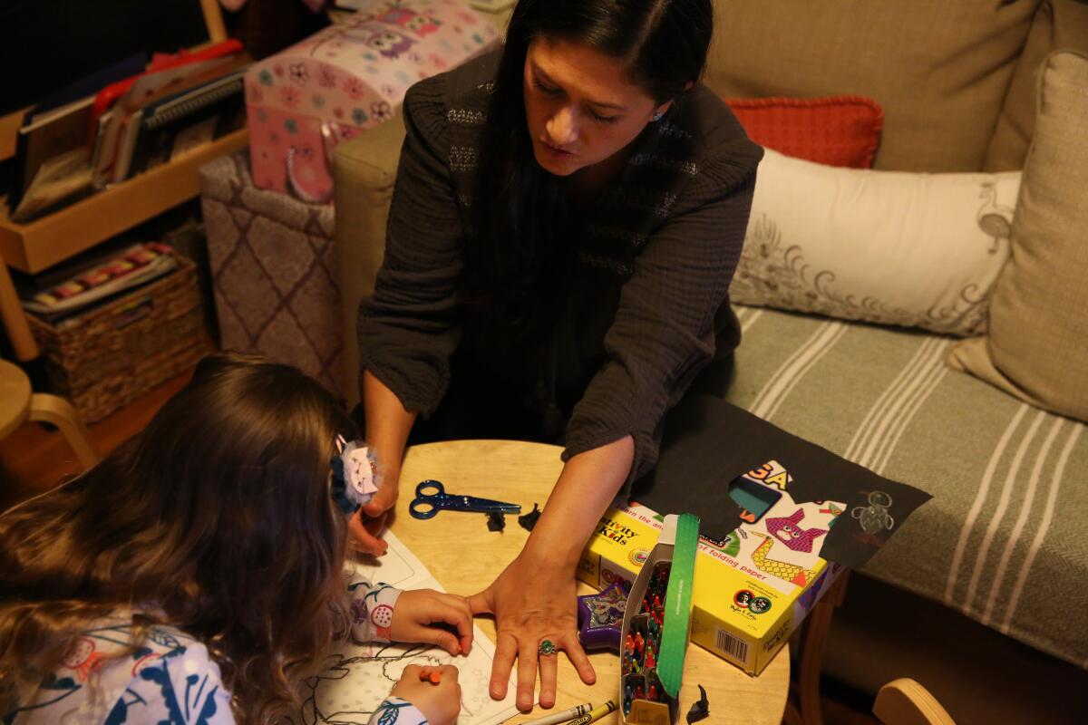 Cindy Carcamo crafts with her 5-year-old daughter at home in Santa Ana.
