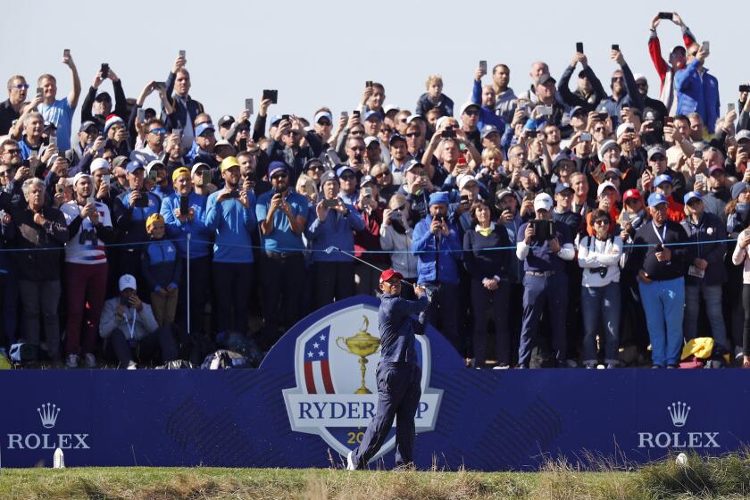 FILE - In a Sunday, Sept. 30, 2018 file photo, Tiger Woods plays a shot from the 4th tee during a singles match on the final day of the 42nd Ryder Cup at Le Golf National in Saint-Quentin-en-Yvelines, outside Paris, France. A decision is looming whether to play the Ryder Cup in Wisconsin in September 2020 with fans or even postpone it until next year. (AP Photo/Alastair Grant, File)