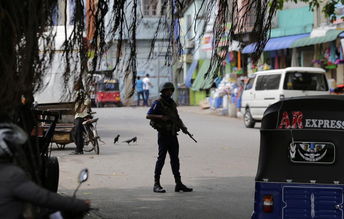 A Sri Lankan naval soldier stands guard at a road leading to a closed market on May Day in Colombo, Sri Lanka