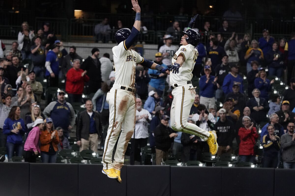 Milwaukee Brewers' Willy Adames celebrates with Christian Yelich after hitting a two-run home run during the eighth inning of a baseball game against the Cincinnati Reds Thursday, May 5, 2022, in Milwaukee. (AP Photo/Morry Gash)