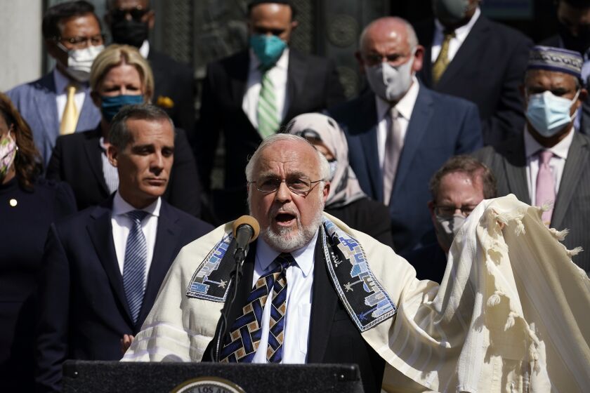 Rabbi Abraham Cooper, center, of the Simon Wiesenthal Center, speaks in front of civic and faith leaders outside City Hall, Thursday, May 20, 2021, in Los Angeles. Faith and community leaders in Los Angeles called for peace, tolerance and unity in the wake of violence in the city that is being investigated as potential hate crimes. (AP Photo/Marcio Jose Sanchez)