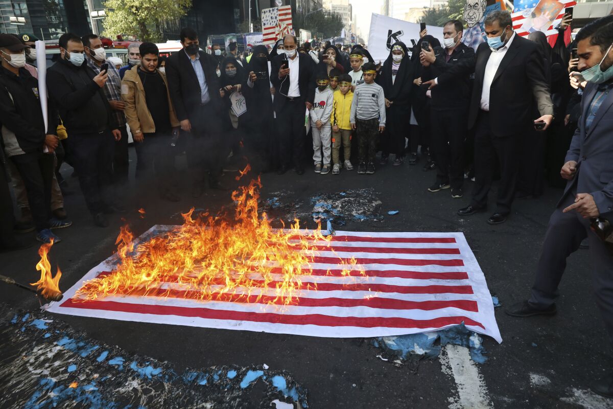 Demonstrators set fire to a mock U.S. flag in a rally in front of the former U.S. Embassy commemorating the anniversary of its 1979 seizure in Tehran, Iran, Thursday, Nov. 4, 2021. The embassy takeover triggered a 444-day hostage crisis and break in diplomatic relations that continues to this day. (AP Photo/Vahid Salemi)