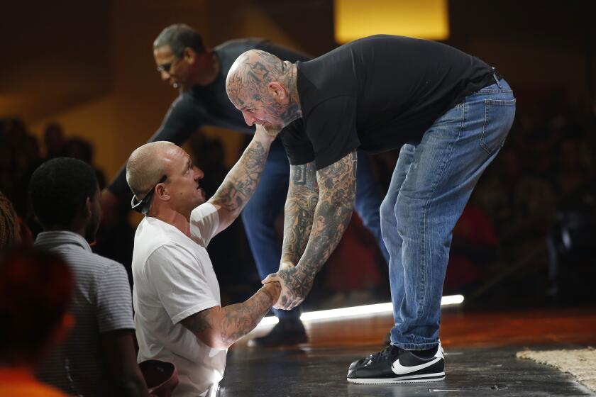 "Taz," a former white supremacist, right, shakes the hand of Andy Yates of Escondido during a service at the Rock Church in Point Loma on August 25, 2019. Taz spoke to the congregation about the troubles he ran into when he was younger before finding God.