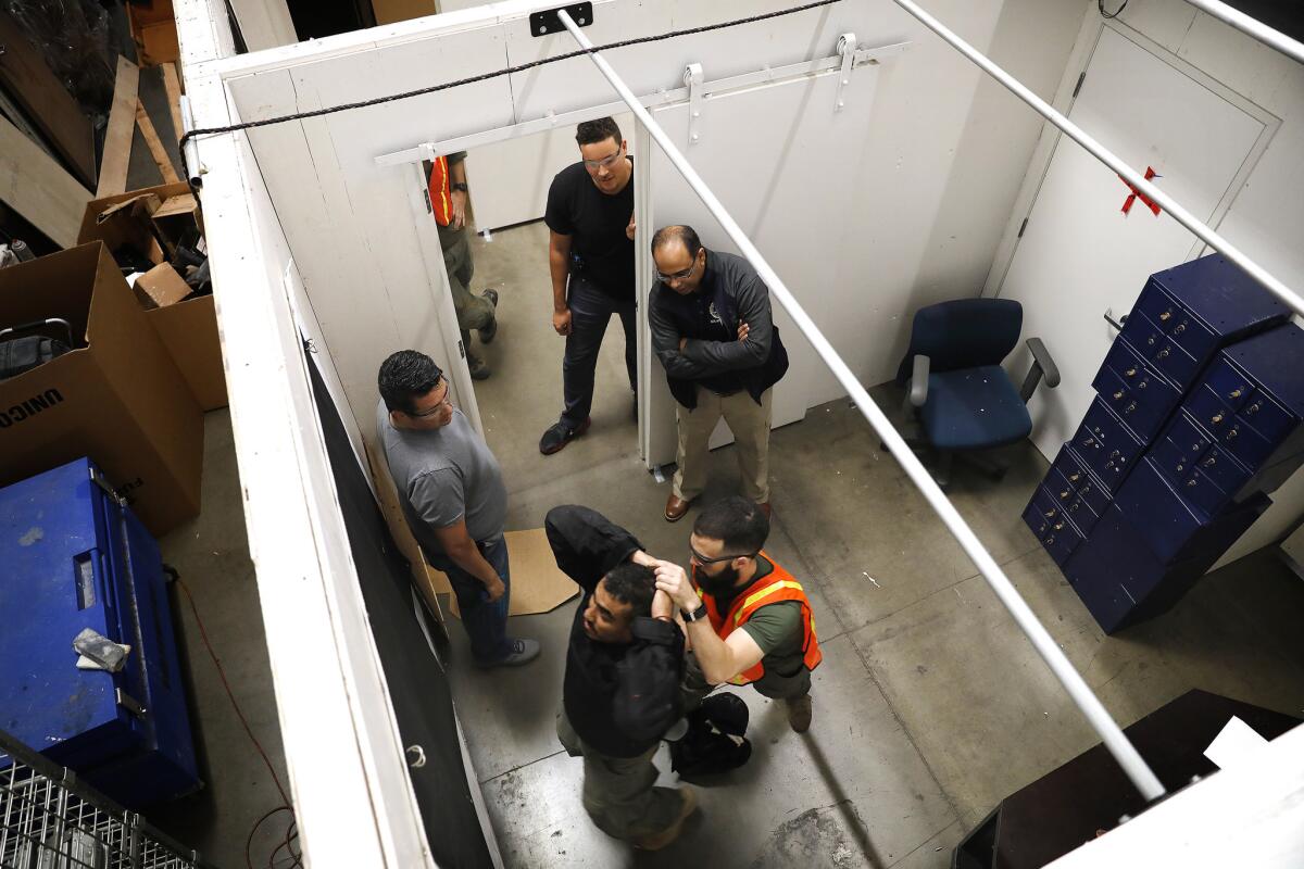 Homeland Security Investigations Citizens Academy participants watch as special agents Gustavo Rios and Nick DeSimone, from bottom left, demonstrate how to handle a suspect.